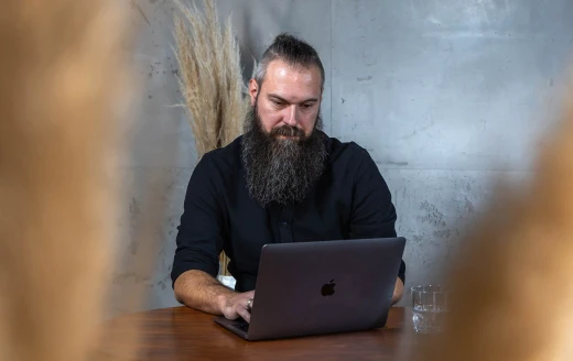 Andre am Tisch mit Laptop